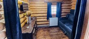 ein Wohnzimmer in einem Blockhaus mit einem Sofa in der Unterkunft Котедж в Карпатах in Huklyvyy