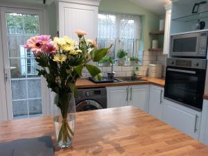 eine Vase mit Blumen auf dem Tisch in der Küche in der Unterkunft WAVENEY in Belfast