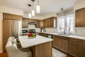 a kitchen with wooden cabinets and a table with flowers on it at Wilmington Vacation Rental Less Than 2 Mi to Downtown! in Wilmington
