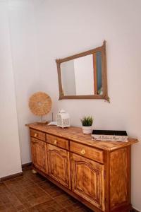 Vestidor de madera en una habitación con espejo en La Barbería de Miguel en El Chorro