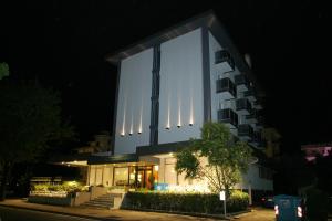 a building with a lit up facade at night at Hotel Domingo in Lido di Jesolo