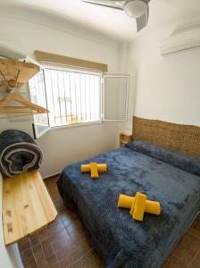 Un dormitorio con una cama con cruces. en La Barbería de Miguel, en El Chorro