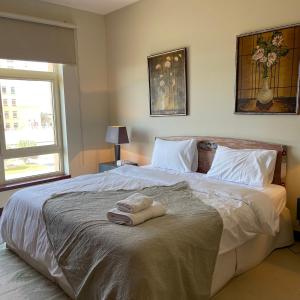 a bedroom with a large bed with two towels on it at شقة باطلاله بحريه - أبراج الشاطئ البيلسان Seafront Apartment in King Abdullah Economic City