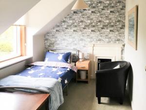 a bedroom with a bed and a chair at April Cottage in Gordon