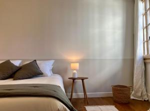 sypialnia z łóżkiem i stołem z lampą w obiekcie La Petite Maison du 9 w mieście Saint-Aignan