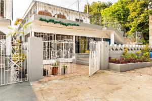 białą bramą przed budynkiem w obiekcie Colorful Private Room Oasis w mieście Montego Bay
