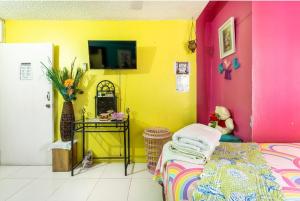 a room with a bed and a yellow wall at Colorful Private Room Oasis in Montego Bay