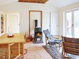 a living room with a fireplace and a table and chairs at 5 person holiday home in YXLAN in Yxlö