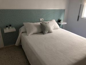 Una cama con dos almohadas encima en un dormitorio. en Sol y playa Sanlúcar, en Sanlúcar de Barrameda