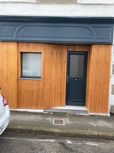 drewniany budynek z czarnymi drzwiami i oknem w obiekcie Appartement centre ville Quimper avec terrasse w mieście Quimper