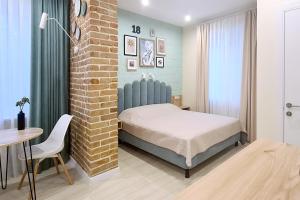 a bedroom with a bed and a brick wall at Shevchenko Loft in Zaporozhye