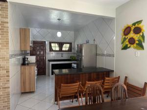 eine Küche mit Tisch und Stühlen und einem Kühlschrank in der Unterkunft casa das bromelias prainha in Paraty