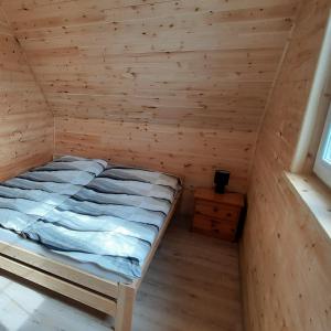 a bedroom with a bed in a wooden room at Na Spokojnej Rodzinne Wakacje in Pogorzelica