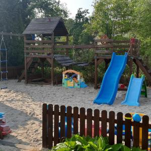 a playground with a slide and a swing set at Na Spokojnej Rodzinne Wakacje in Pogorzelica