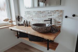 a bathroom with a stone sink on a wooden counter at Deine MEERZeit in Büsum