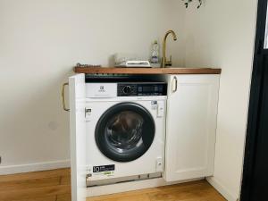 uma máquina de lavar roupa numa cozinha com um lavatório em Vieux Marly-le-Roi - Studio bien equipé - Matelas haut qualité em Marly-le-Roi