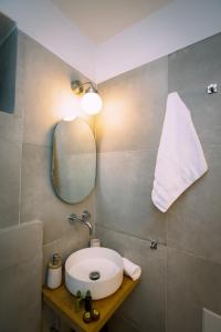ein Bad mit einem Waschbecken und einem Spiegel in der Unterkunft MYKONOS HOUSE Wanderlust , Mykonos Town in Mykonos Stadt