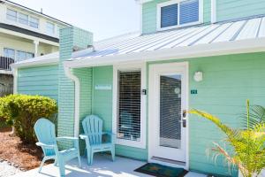 two blue chairs sitting on the porch of a house at Sea Cabin 2D in Destin