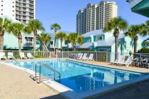 a swimming pool with chairs and palm trees at Sea Cabin 2D in Destin