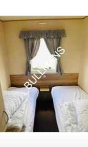 A bed or beds in a room at Delightful 3 bedroom caravan, HAVEN site the orchards