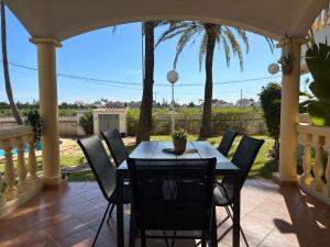 a table and chairs on a porch with palm trees at La Giralda in Denia
