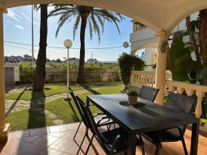 a black table and chairs on a porch with palm trees at La Giralda in Denia