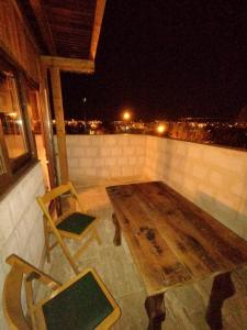 einen Holztisch und Stühle auf einem Balkon in der Nacht in der Unterkunft Begam Butik Otel in Avanos