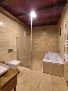 a bathroom with a tub and a toilet and a sink at Begam Butik Otel in Avanos