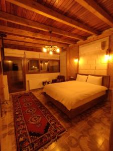 a bedroom with a large bed and a rug at Begam Butik Otel in Avanos