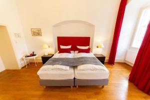 a bedroom with a bed with a red headboard at Hotel zum Ritter St. Georg in Heidelberg