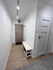 a white room with a door and a bench at Apartament Piastowska in Gdańsk