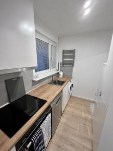 a kitchen with a sink and a stove top oven at Apartament Piastowska in Gdańsk