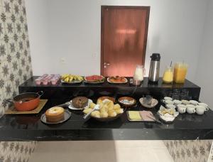 un buffet con muchos tipos diferentes de comida en una mesa en POUSADA FÊNIX en Viçosa