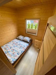 mały pokój z łóżkiem w drewnianym domku w obiekcie Domki letniskowe Na Stoku we Władysławowie