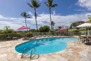 a swimming pool with chairs and tables and palm trees at Hale Hāhālua - Hale Hahalua - Serenity and Ocean Views in Kona now with AC in Kailua-Kona