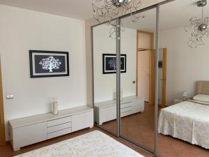 1 dormitorio con cama y espejo grande en Casa Vacanze AL CAPRIANO appartamento Lampone, en Cantello