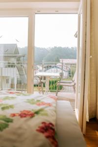 Habitación con cama y balcón con mesa y sillas. en Stockers kleines Dorfhotel, en Deutsch Goritz