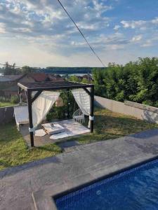 a gazebo by a swimming pool next to at Vila Sunset Jugovo in Udovice