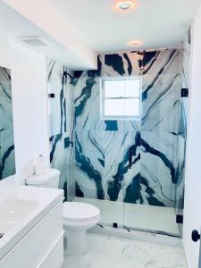a white bathroom with a toilet and a sink at Stylish 1BR Condo 1Block to Aventura Mall in Aventura