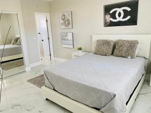 a bedroom with a large bed and a mirror at Stylish 1BR Condo 1Block to Aventura Mall in Aventura