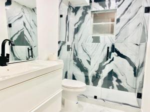 a bathroom with a shower and a toilet and a sink at Stylish 1BR Condo 1Block to Aventura Mall in Aventura