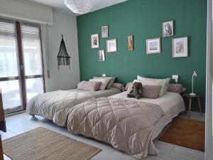 2 letti in una camera da letto con pareti verdi di Casavacanze "La Casina" in Valtellina a Sondrio