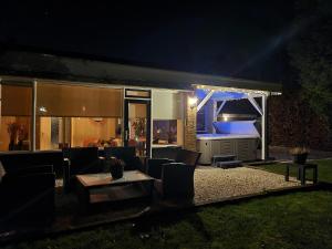 a patio with a table and chairs at night at Secret Wellness Oase in Holten