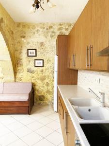 a kitchen with wooden cabinets and a sink and a counter at Lithos House and Studios in Kissamos