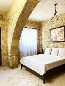 a bedroom with a bed in a stone wall at Lithos House and Studios in Kissamos