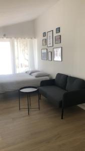 ein Schlafzimmer mit einem Bett, einem Sofa und einem Tisch in der Unterkunft Studio refait à neuf avec jardin Aigues Mortes in Aigues-Mortes