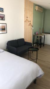 Zimmer mit einem Bett, einem Sofa und einem Tisch in der Unterkunft Studio refait à neuf avec jardin Aigues Mortes in Aigues-Mortes