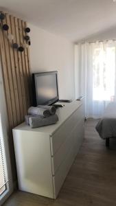 ein Schlafzimmer mit einer Kommode und einem Laptop darauf in der Unterkunft Studio refait à neuf avec jardin Aigues Mortes in Aigues-Mortes