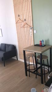einen Tisch und Stühle im Wohnzimmer mit Laptop in der Unterkunft Studio refait à neuf avec jardin Aigues Mortes in Aigues-Mortes
