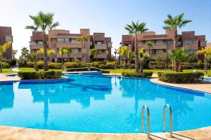 a swimming pool in front of a resort at Cozy Golf Apartment Wifi 4k-TV Netflix in Marrakech